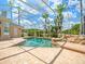 Spacious screened-in pool area with brick-paver deck and a rock waterfall feature providing a luxurious backyard at 4521 Cheval Blvd, Lutz, FL 33558