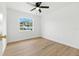 Empty bedroom featuring neutral walls, wood floors, and a window at 4611 W Bay Court Avenue, Tampa, FL 33611