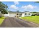 Charming single-story home featuring a brick exterior, blue shutters, manicured lawn and long driveway at 4611 W Bay Court Avenue, Tampa, FL 33611