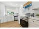 Bright kitchen showcasing stainless steel appliances, white cabinetry, and a modern backsplash at 4611 W Bay Court Avenue, Tampa, FL 33611