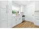 Updated kitchen featuring white cabinets, stainless steel dishwasher, and a window overlooking the outdoors at 4611 W Bay Court Avenue, Tampa, FL 33611