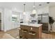 Modern kitchen with stainless steel appliances, island with seating, white cabinetry and pendant lighting at 4611 W Bay Court Avenue, Tampa, FL 33611