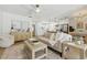 Bright, open-concept living space with hardwood floors, ceiling fan, comfortable furniture, and seamless kitchen access at 4611 W Bay Court Avenue, Tampa, FL 33611