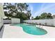 Gorgeous backyard pool surrounded by a white concrete deck and white fence for privacy at 4611 W Bay Court Avenue, Tampa, FL 33611