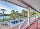 Balcony view overlooking a pool and lush landscape with palm trees and waterfront at 4915 South Rd, New Port Richey, FL 34652