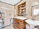 Bathroom with and sinks, wood cabinet, tile floor, round mirror, and open shelving at 4915 South Rd, New Port Richey, FL 34652