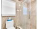Bathroom with glass enclosed shower, white toilet, tissue box and tile flooring at 4915 South Rd, New Port Richey, FL 34652
