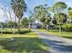Long driveway leading to a beautiful home, surrounded by mature trees and well-manicured landscaping at 4915 South Rd, New Port Richey, FL 34652