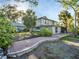 Backyard with brick patio, a screened in porch, and mature trees enhancing outdoor living at 4915 South Rd, New Port Richey, FL 34652