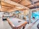 Garage with exposed wooden beams, pool table and dodge truck parked inside at 4915 South Rd, New Port Richey, FL 34652