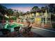 Outdoor living space with a fenced pool, patio seating, and a two-story home in the background at 4915 South Rd, New Port Richey, FL 34652