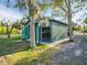 Metal shed with open doors, nestled among mature trees, providing ample storage and workspace at 4915 South Rd, New Port Richey, FL 34652