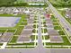 An aerial view of the neighborhood featuring sidewalks and a pond at 5474 Flint Hills Dr, Wimauma, FL 33598