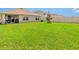 Spacious backyard featuring well-maintained lawn and partial view of neighboring homes at 5474 Flint Hills Dr, Wimauma, FL 33598