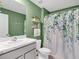 Bathroom with green walls, white marbled countertop, and floral shower curtain at 5474 Flint Hills Dr, Wimauma, FL 33598