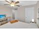 Cozy bedroom featuring a ceiling fan, and a bed with a wooden tray and matching nightstands at 5474 Flint Hills Dr, Wimauma, FL 33598