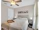 Cozy bedroom with ceiling fan, and a bed with a wooden tray and matching nightstands at 5474 Flint Hills Dr, Wimauma, FL 33598