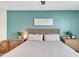 Bright bedroom featuring a queen-sized bed, blue accent wall, and matching nightstands at 5474 Flint Hills Dr, Wimauma, FL 33598