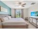 Bright bedroom featuring a queen-sized bed, blue accent wall, and a view of the backyard at 5474 Flint Hills Dr, Wimauma, FL 33598