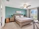 Comfortable bedroom featuring a queen-sized bed, blue accent wall, and ample natural light at 5474 Flint Hills Dr, Wimauma, FL 33598