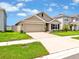 Attractive single-Gathering home featuring a well-maintained lawn and spacious two-car garage at 5474 Flint Hills Dr, Wimauma, FL 33598