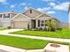 Inviting single-story home with a well-kept lawn, front garden, and a convenient two-car garage at 5474 Flint Hills Dr, Wimauma, FL 33598