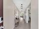 Bright hallway with stylish light fixture, neutral walls, and decorative console table and mirror at 5474 Flint Hills Dr, Wimauma, FL 33598