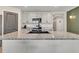 Modern kitchen island featuring granite countertops, sleek faucet, and stylish light gray cabinetry at 5474 Flint Hills Dr, Wimauma, FL 33598