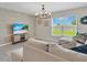 Bright living room featuring a comfortable sectional sofa, stylish rug, and decorative chandelier at 5474 Flint Hills Dr, Wimauma, FL 33598