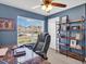 Bright office with desk, ceiling fan, blue walls, and a large window view at 5474 Flint Hills Dr, Wimauma, FL 33598
