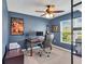 Bright office with desk, ceiling fan, blue walls, and a window with blinds at 5474 Flint Hills Dr, Wimauma, FL 33598
