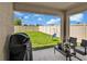 Covered patio with outdoor seating, offering a view of the lush, green backyard at 5474 Flint Hills Dr, Wimauma, FL 33598