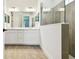 Well-lit bathroom with double sinks, a large mirror, and a tiled shower at 8077 Tea Olive Ter, Palmetto, FL 34221