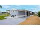 Charming home featuring a covered parking area, bench seating, and well-manicured landscaping at 108 W Saint Johns Way # 210, Apollo Beach, FL 33572