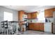 Functional kitchen featuring wood cabinets, breakfast table with white stools, and modern appliances at 108 W Saint Johns Way # 210, Apollo Beach, FL 33572