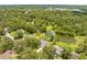 Expansive aerial view capturing a serene neighborhood with lush greenery, a tranquil pond, and well-maintained homes at 1271 Candlelight Blvd, Brooksville, FL 34601