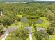 Breathtaking aerial view showcasing lush greenery, a large pond, and well-spaced homes in a peaceful, suburban setting at 1271 Candlelight Blvd, Brooksville, FL 34601