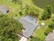 Aerial view highlighting the screened pool and expansive backyard, surrounded by lush greenery and a peaceful pond at 1271 Candlelight Blvd, Brooksville, FL 34601