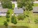 This aerial view showcases a beautiful home with a screened pool, lush lawn, and a tranquil pond in the backyard at 1271 Candlelight Blvd, Brooksville, FL 34601