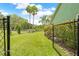 Spacious backyard with a chain-link fence overlooking a tranquil body of water at 1271 Candlelight Blvd, Brooksville, FL 34601