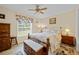 Neutral bedroom with ceiling fan, bed, night stands, window, bench, and wood floors at 1271 Candlelight Blvd, Brooksville, FL 34601