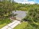 A picturesque home featuring a well-manicured lawn, a classic driveway, and charming exterior, complete with a tranquil pond backdrop at 1271 Candlelight Blvd, Brooksville, FL 34601