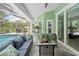Covered patio with comfortable seating beside a screened-in pool area at 1271 Candlelight Blvd, Brooksville, FL 34601