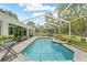 Backyard pool featuring a screened-in enclosure, landscaped patio, and outdoor seating at 1271 Candlelight Blvd, Brooksville, FL 34601