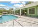 Beautiful pool area featuring a screened enclosure, spacious patio, and manicured landscaping at 1271 Candlelight Blvd, Brooksville, FL 34601