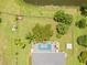 Aerial view showcasing a sparkling pool and meticulously maintained backyard, bordered by lush greenery and a serene pond at 1271 Candlelight Blvd, Brooksville, FL 34601