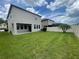 Large, green backyard featuring a white fence and neighboring houses at 1596 Ludington Ave, Wesley Chapel, FL 33543