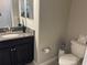 Well-maintained powder room showcasing dark vanity, granite countertop, and classic fixtures at 1596 Ludington Ave, Wesley Chapel, FL 33543