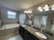 Bathroom featuring double sinks, granite countertops, and a soaking tub at 1596 Ludington Ave, Wesley Chapel, FL 33543