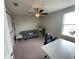 Bedroom features ceiling fan, neutral walls, grey futon, desk, and simple shelving for versatile use at 1596 Ludington Ave, Wesley Chapel, FL 33543